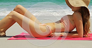 Side view of Caucasian woman in hat relaxing on the beach 4k