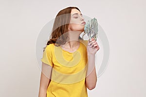 Side view of cheerful rich attractive young woman in yellow casual style T-shirt standing and air