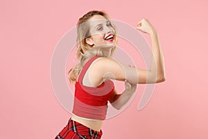 Side view of cheerful young blonde woman girl in red sexy clothes posing isolated on pastel pink wall background studio