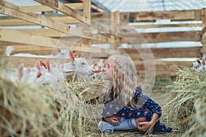 side view of child going to kiss goat