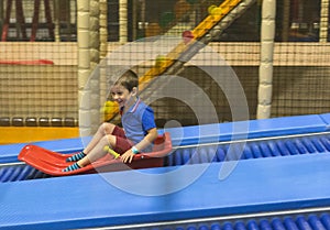 Child on slide ride in play area