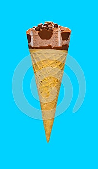 side view of chocolate flavor ice cream cone on a blue background