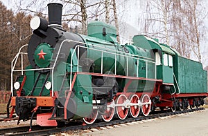 Side view of classic old green soviet steam locomotive with red star