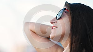 Side view close up face of happy woman in sunglasses enjoying sunset standing outdoor