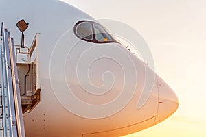 Side view close up on the nose of a passenger plane at sunset