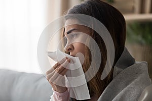 Side view close up woman holding paper tissue sneezing