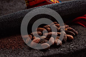 Side view of cocoa and cacao powder on a traditional metate, used in Mexican indigenous culture