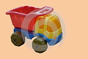 side view colorful plastic truck toy on orange background, object, toy, play, banner, template, decor, copy space