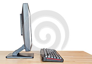 Side view computer display and keyboard on table