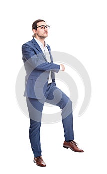 Side view confident businessman climbing a imaginative staircase isolated on white background. Concept of career development and photo