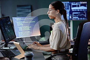 Middle Eastern Female Programmer Using Computer Writing Code at Workstation in Office