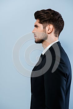 Side view of confident serious man in black suit