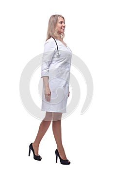 confident young woman doctor striding forward . isolated on a white background.