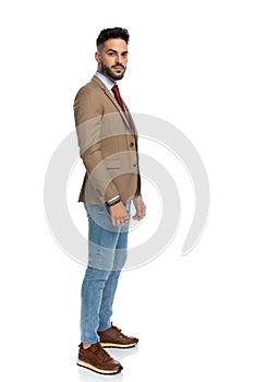 Side view of cool young guy in smart casual outfit with sneakers