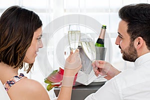 Side view of couple celebrating with sparkling wine.