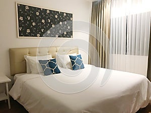 Side view of cozy hotel bed or house bedroom with blue cushion,