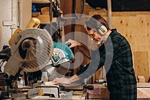 Side view of craftsperson using circular saw