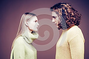 Side view. Curly man and blonde woman facing each other, eyes open. Concept of confrontation in the family. A couple