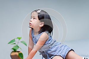 Side view of a cute girl sits lazily gazing upwards