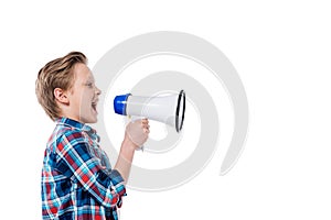 Side view of cute little boy holding megaphone and screaming