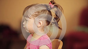 Side view of cute little girl eating soup or muesli from bowl.