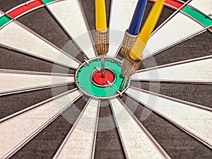 Side view of a dartboard with three darts in the bull`s eye.