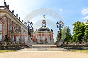 Side view of Das Neue Palast, in park Sanssouci, Potsdam, Germany with its stairs as entrance, the forged iron lanterns, and a p photo