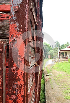 SIDE VIEW OF DELAPIDATED WOODEN TRAIN COACH AT AN OLD STATION