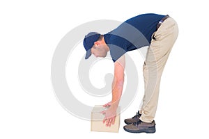 Side view of delivery man picking cardboard box