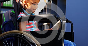 Side view of disabled African American schoolgirl reading a book in library at school 4k