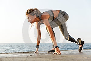 Side view of disabled athlete woman with prosthetic leg photo