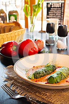 Side view on a dish of eastern european cuisine golubtsy stuffed cabbage leaves with meat or vegetable, with sour cream