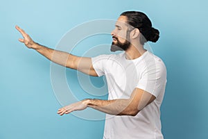 Side view of disoriented blind man with beard standing with stretched arms, searching for way.