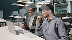 Side view diverse happy colleagues men african businessman talking with arabian employee worker having fun together