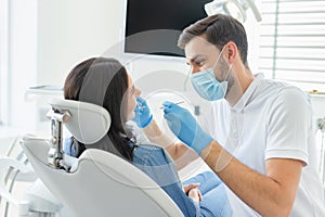 Side view of Doctor treating patient teeth in modern dental clinic