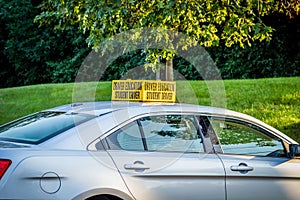 Side view of drivers ed car with yellow student driver sign on roof