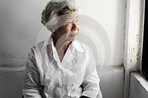 Side view of elderly asian woman with thoughtful face expression photo