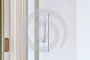 Side view of electrical rocker light switch mounted on white interior wall
