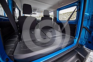 side view of empty open car trunk with seats folded into flat flor of suv crossover. open door