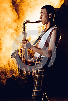 side view of expressive professional saxophonist playing sax