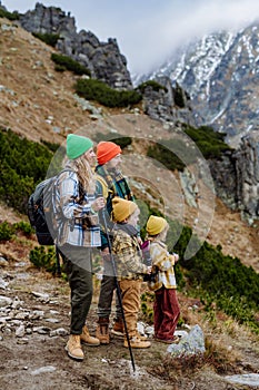 Bočný pohľad na rodinu s malými deťmi na jesenné hory. Koncept zdravého životného štýlu.