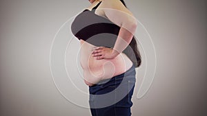 Side view of fat unrecognizable Caucasian woman retracting belly and relaxing. Obese woman`s body. Obesity, overweight