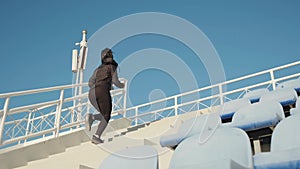 Side view of female fitness coach running up the stairs outdoors before workout slow motion