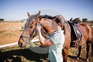 Side view of female jockey fastening bridle