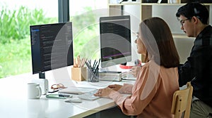Side view of female programmer working with computer at modern office. Developing programming