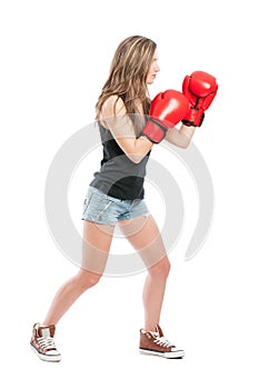 Side view of a female wearing red boxing gloves