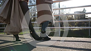 Side view of females legs walking on bridge