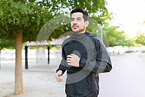 Side view of a fit man running in the park