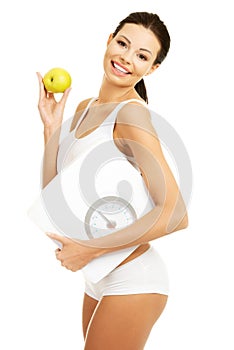 Side view fit woman with an apple and weight
