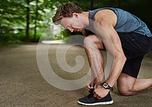 Side View of a Fit Young Man Tying Shoelace